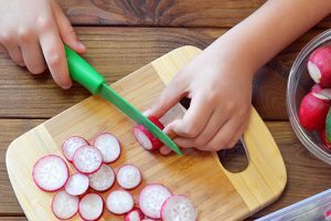 enfant-coupe-radis-planche